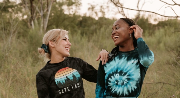 two girls smiling and laughing outside