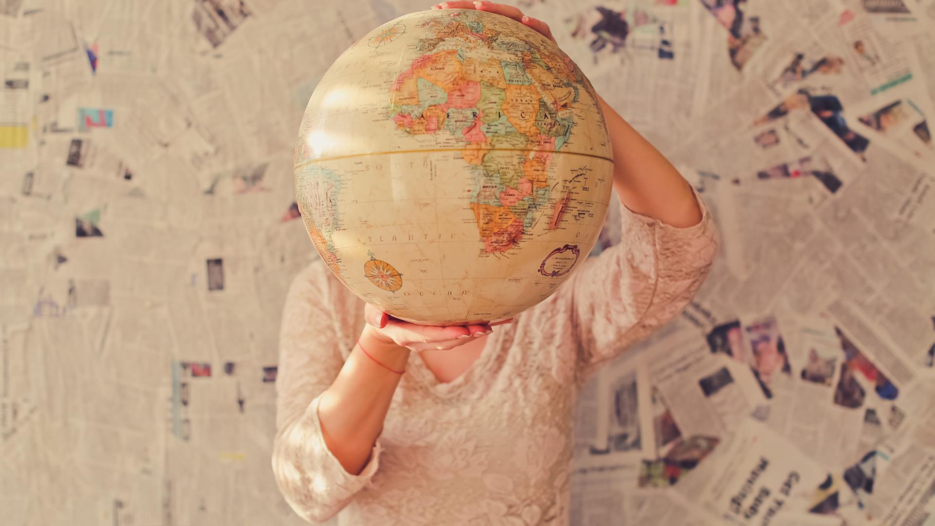 person-holding-globe